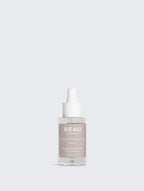 Skincare serum bottle labeled 'REAU' on a light gray background