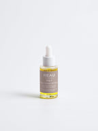 Bottle of REAU skincare serum on a white background