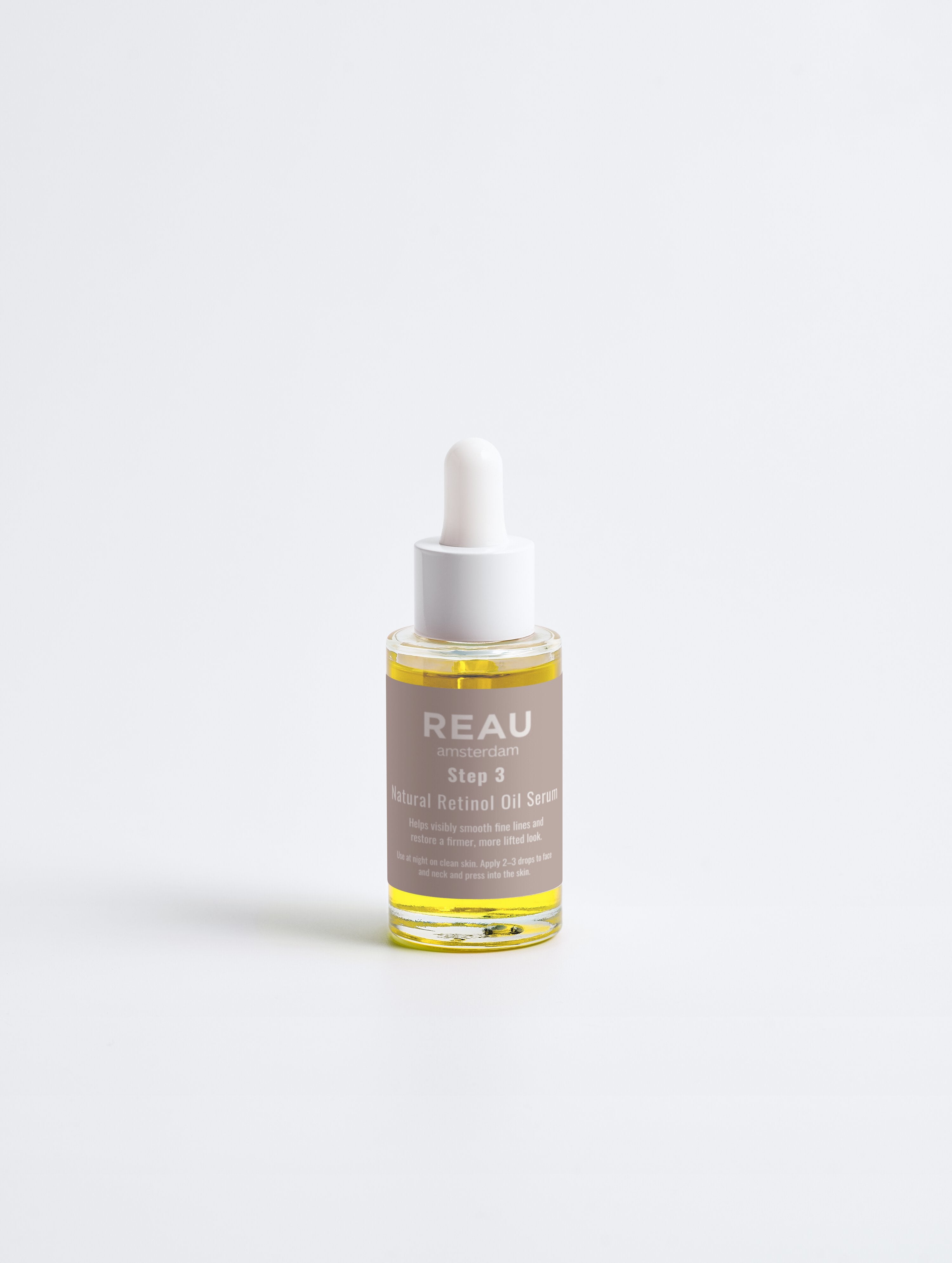 Bottle of REAU skincare serum on a white background